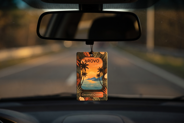AROVO Coconut Cream Duftbaum am Innenspiegel eines Autos im Abendlicht