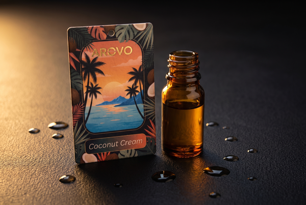 AROVO Coconut Cream Duftbaum neben einem Fläschchen Duftöl mit Öltropfen auf schwarzem Untergrund