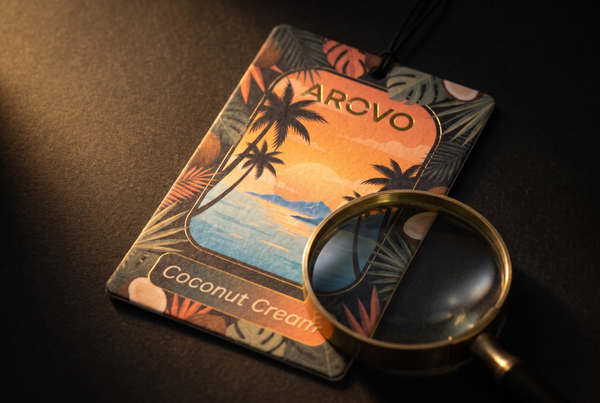 AROVO Coconut Cream Duftbaum mit einer Lupe darüber auf schwarzem Untergrund