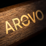 Makroaufnahme des goldenen AROVO-Schriftzugs auf der Walnussholzmaserung